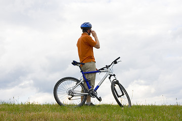 Image showing Man with mountain bike talking on cell phone