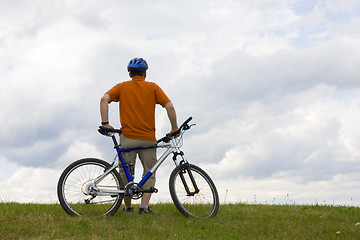 Image showing Man standing by his mountain bike