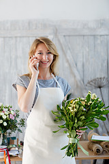 Image showing Florist with phone and bouquet