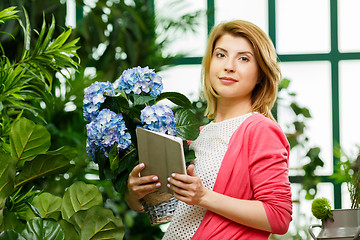 Image showing Florist with bouquet and tablet