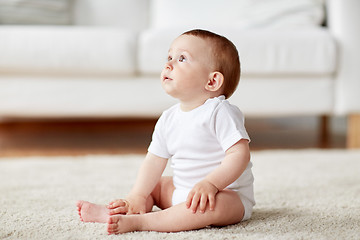 Image showing happy baby boy or girl sitting on floor at home