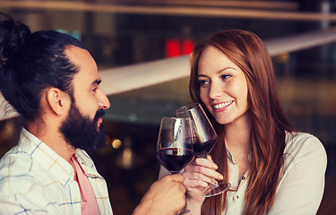 Image showing couple drinking red wine and clinking glasses