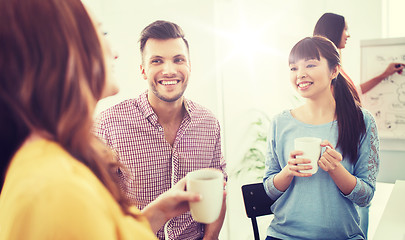 Image showing happy creative team drinking coffee at office