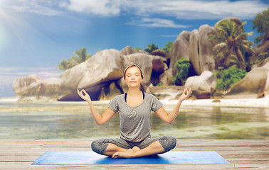 Image showing woman doing yoga meditation in lotus pose on beach