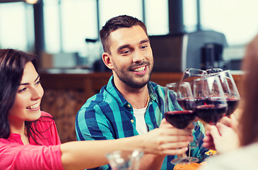 Image showing friends clinking glasses of wine at restaurant