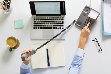 Image showing businesswoman calling on phone at office table