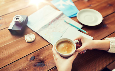 Image showing close up of hands with coffee cup and travel stuff