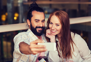 Image showing couple taking selfie by smartphone at restaurant