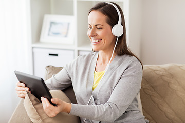 Image showing happy woman with tablet pc and headphones at home