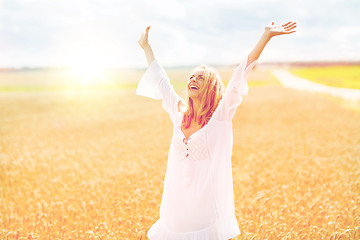 Image showing smiling young woman in white dress on cereal field