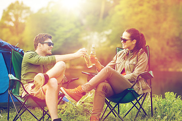 Image showing happy couple clinking drinks at campsite tent