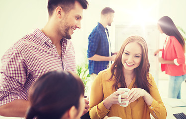 Image showing happy creative team drinking coffee at office