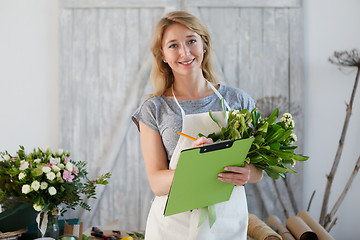 Image showing Beautiful florist writes down orders