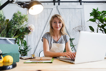 Image showing Young woman florist at table