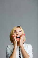 Image showing Surprised happy girl looking up