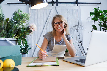 Image showing Woman florist sitting at table