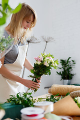 Image showing Young blonde in flower shop