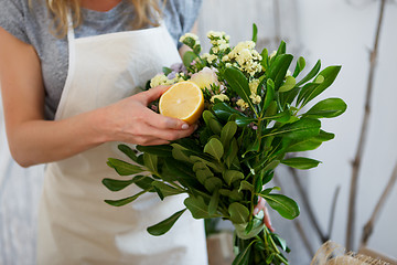 Image showing Woman composes bouquet with lemon