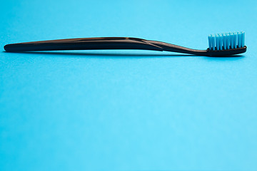 Image showing Black toothbrush with blue bristle