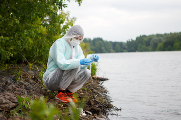 Image showing Young environmentalist takes water samples