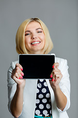 Image showing Smiling young model holds tablet