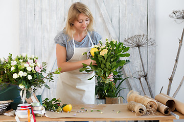 Image showing Blonde composes bouquet with lemon