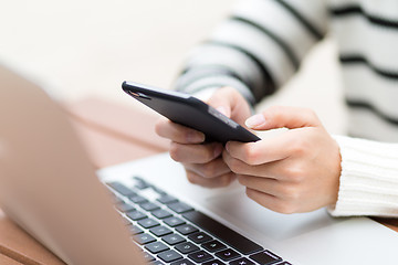 Image showing Woman sending text message on cellphone