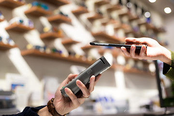 Image showing Woman paying with NFC technology on mobile phone