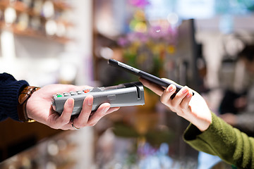 Image showing Woman paying with NFC technology on mobile phone