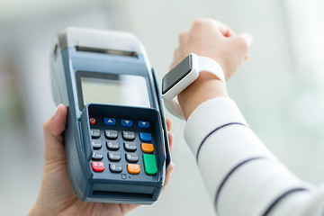 Image showing Woman using smartwatch to pay the bill