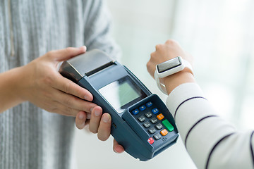 Image showing Woman using cellphone for paying the bill