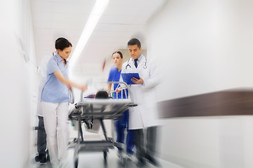 Image showing medics and patient on hospital gurney at emergency