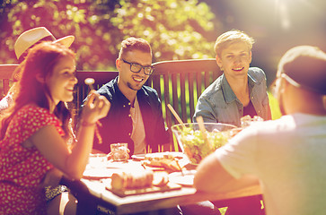 Image showing happy friends having dinner at summer garden party