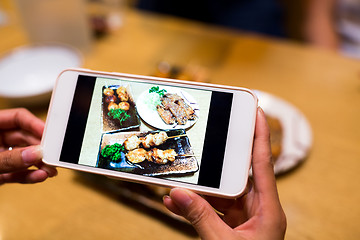 Image showing Taking photo by mobile phone before having dinner