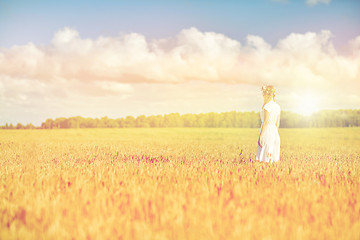 Image showing happy young woman in flower wreath on cereal field