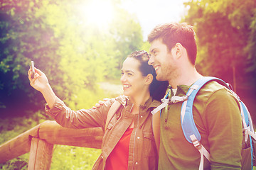 Image showing couple with backpacks taking selfie by smartphone