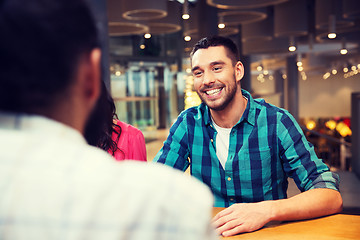 Image showing happy man meeting with friends at restaurant