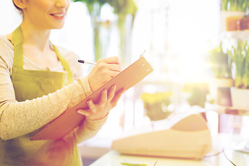 Image showing close up of woman with clipboard at flower shop