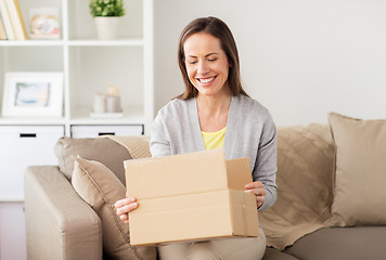 Image showing smiling woman opening cardboard box