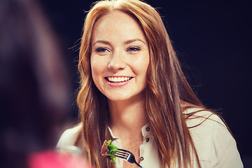 Image showing happy young woman having dinner at restaurant