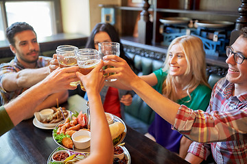 Image showing happy friends drinking beer at bar or pub