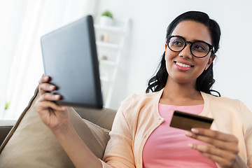 Image showing happy woman with tablet pc and credit card at home