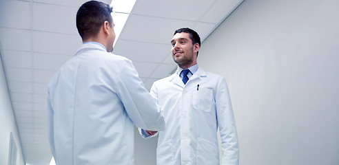 Image showing smiling doctors at hospital doing handshake