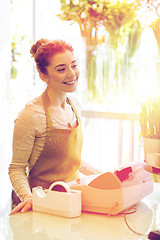 Image showing smiling florist woman at flower shop cashbox