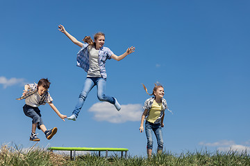 Image showing Brother and sisters playing on the field at the day time.