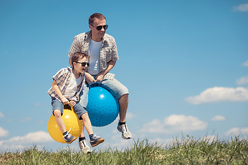 Image showing Father and son playing on the field at the day time.