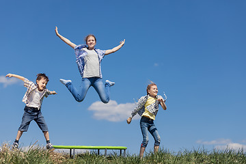 Image showing Brother and sisters playing on the field at the day time.