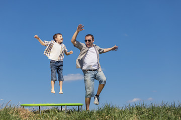 Image showing Father and son playing on the field at the day time.