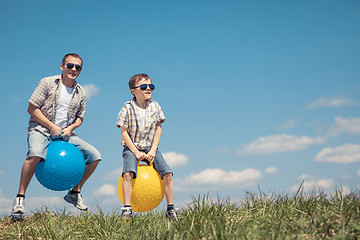 Image showing Father and son playing on the field at the day time.