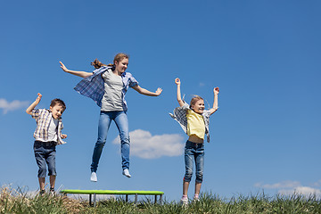 Image showing Brother and sisters playing on the field at the day time.